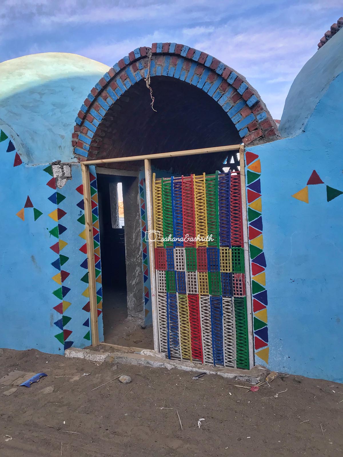 Rainbow themed louvered door to a nubian vaulted house
