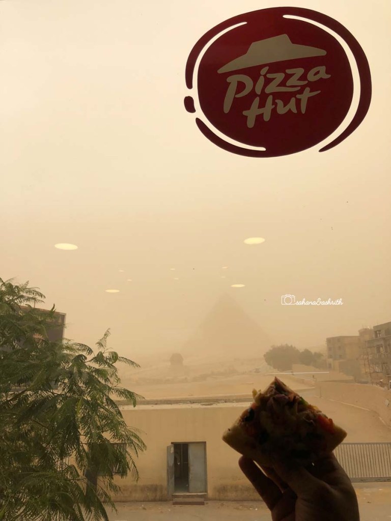Blurred view Giza pyramids from Pizzahut's window