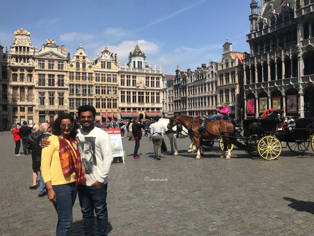 Indian couple travellers standing in ebautiful plaza of brussels