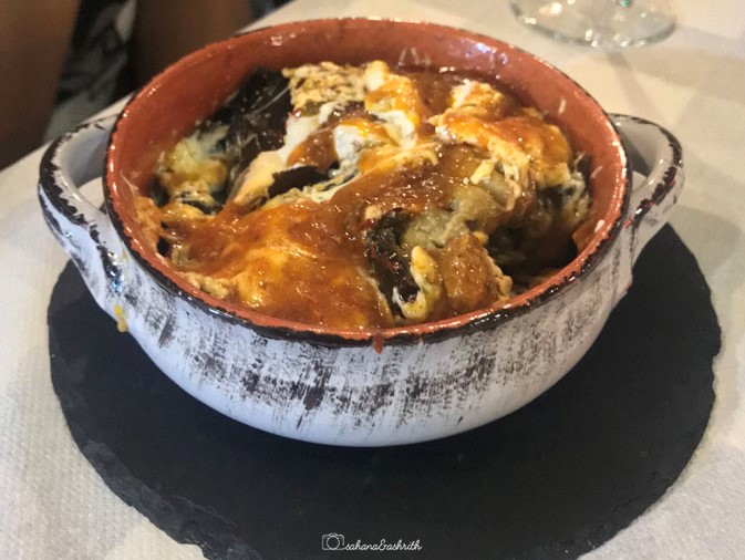 Greek dish Eggplant Saganaki in a white bowl