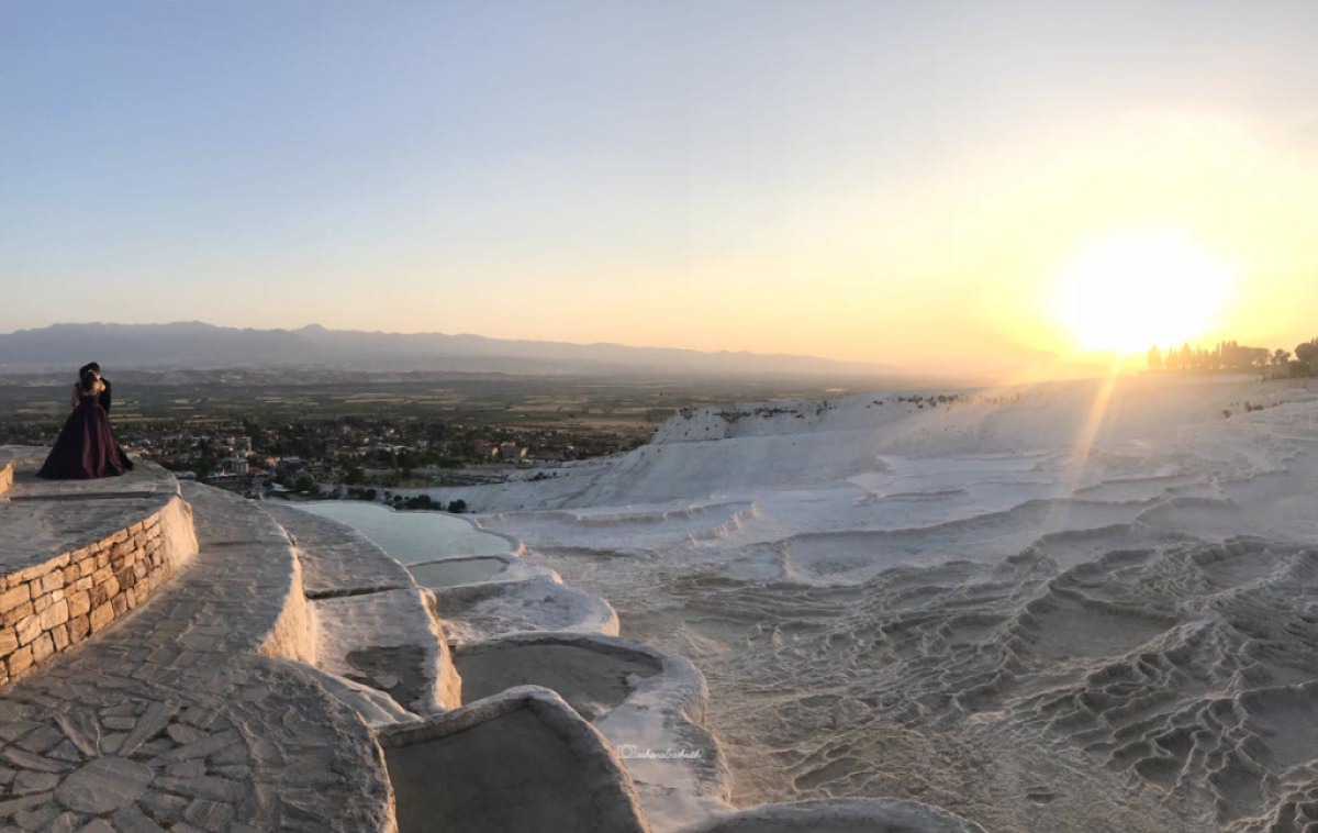Couple photoshoot in progress during sunset time by the white traventine side at Pamukkale