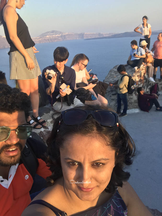 Flock of tourists clicking photos in Oia