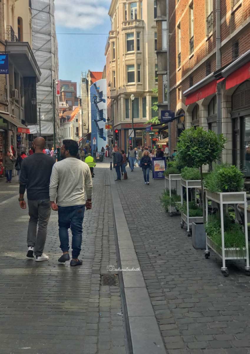 Indian travellers walking on the paved pathways of Brussels 
