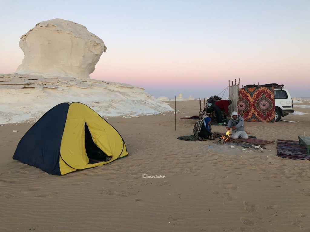 A tent at the foothill of giant White lime formations on the brown desert