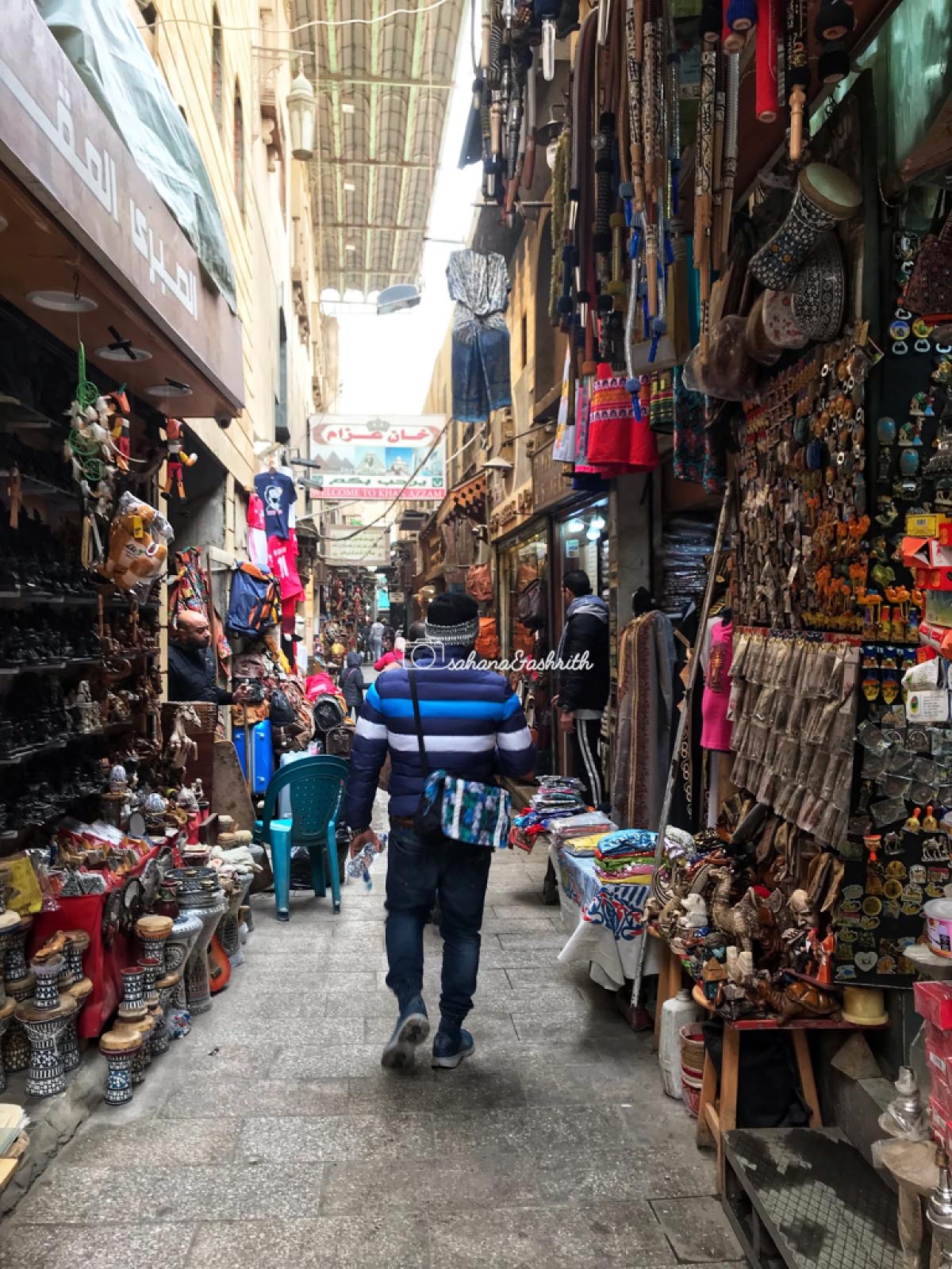 Indian traveller walking in the narrow alleys with shops on either side