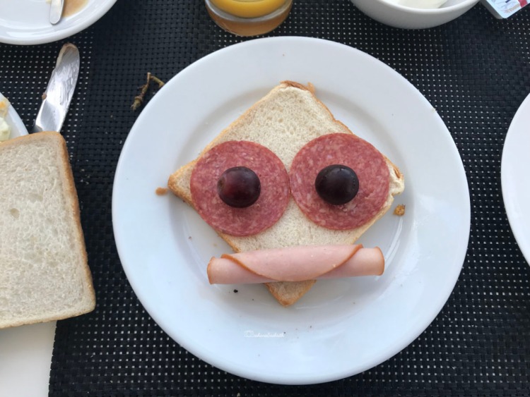 Bread slice with chicken fillet on top with cherries resembles face of Donald duck