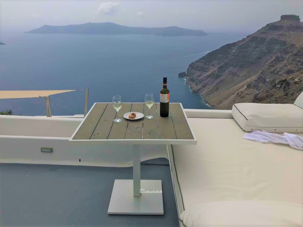 bottle of santorini wine kept on a table with the beautiful view of mediterranean sea in the background