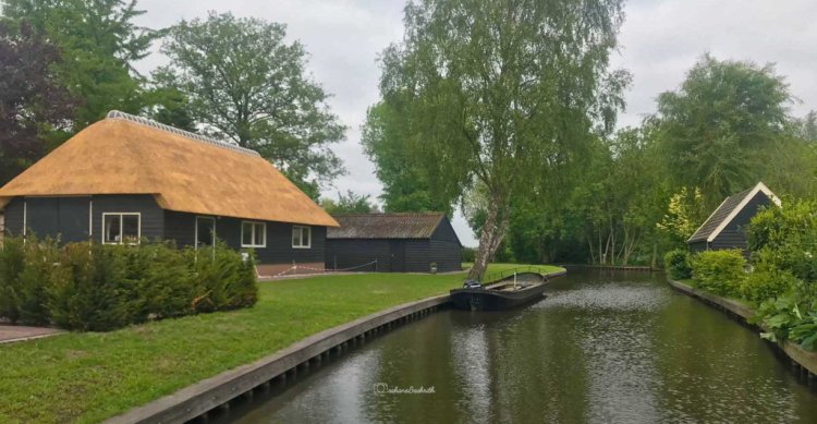 Giethoorn village with canal and traditional dutch house with sloped roof on either side