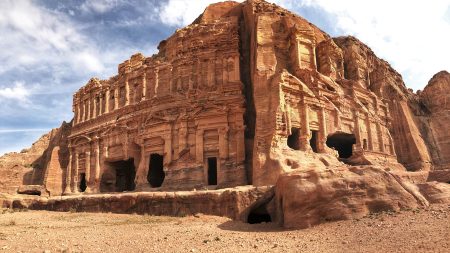 Colossal rock mountain carved with openings and ornamentation on the facade at Jordan