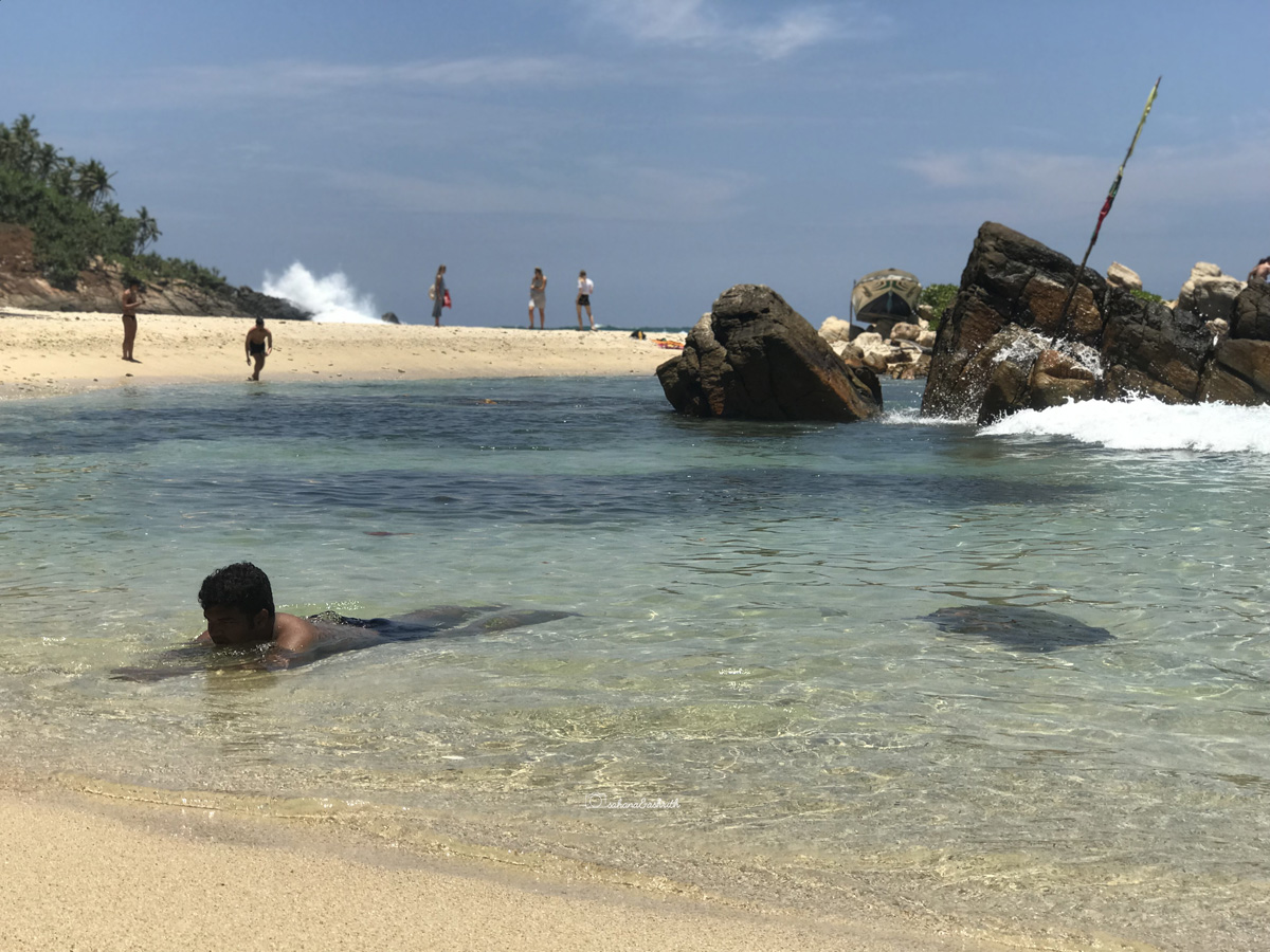 vacaywork author soaking in the shallow ocean water at secret beach, Mirissa