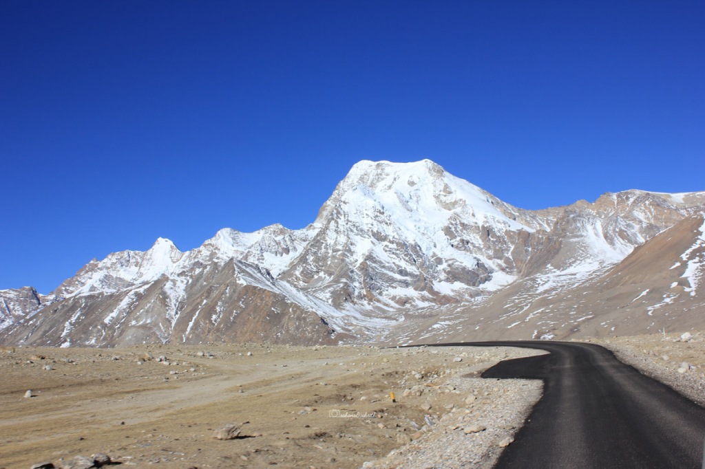 Asphalt road in the middle of Himalayan snow caped mountains in Sikkim