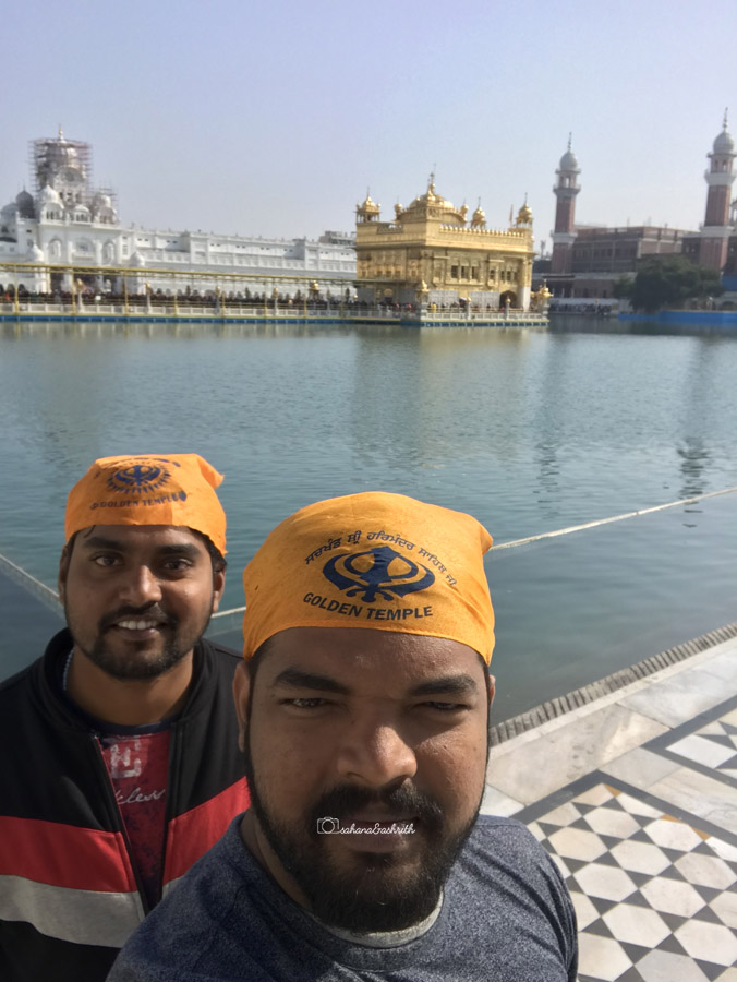 Indian men with head covered in orange scarf  at Amritsar Golden temple