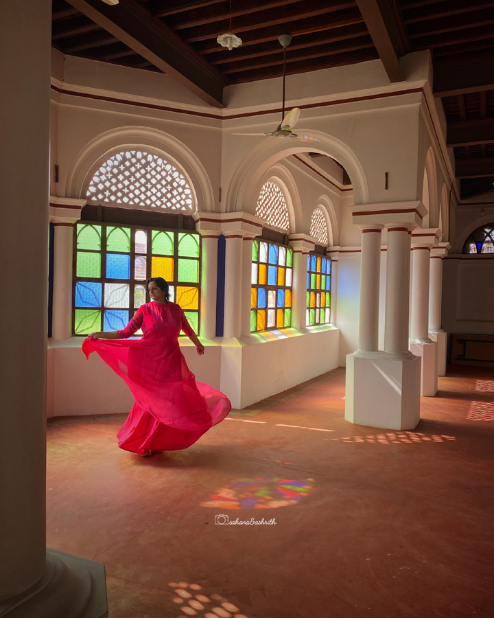 beautiful girl from India wearing pink flowing gown swirling inside of antiquely decored room