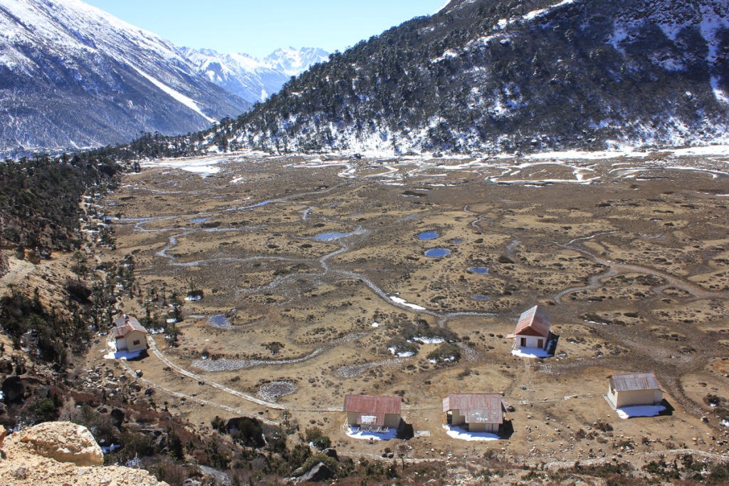 Chopta valley surrounded by Himalayan mountains and small houses