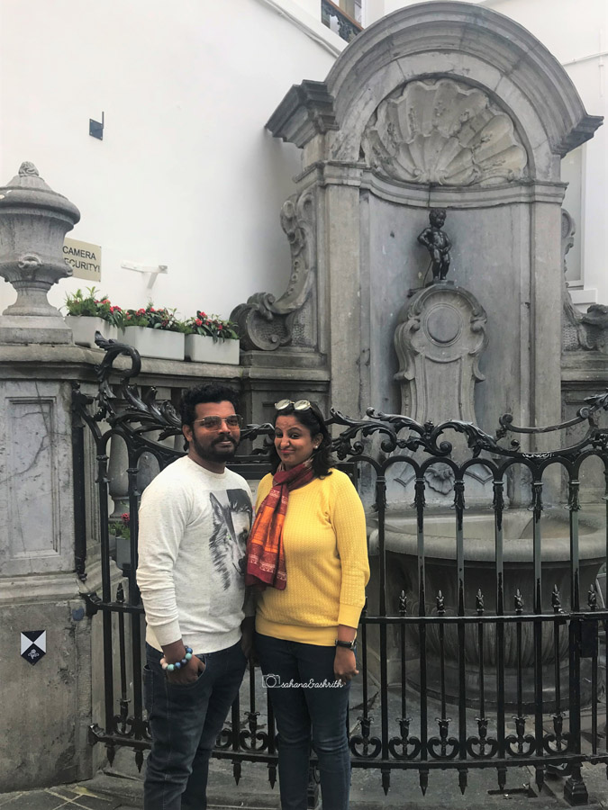 Indian couple travelers standing in front of mannikin pis at Brussels in Belgiun