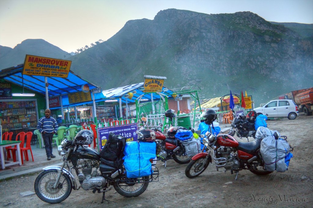Four Royal Enfield bullet bikes parked in front of a dhaba with Himalayas in the background at Marthi near Rothang