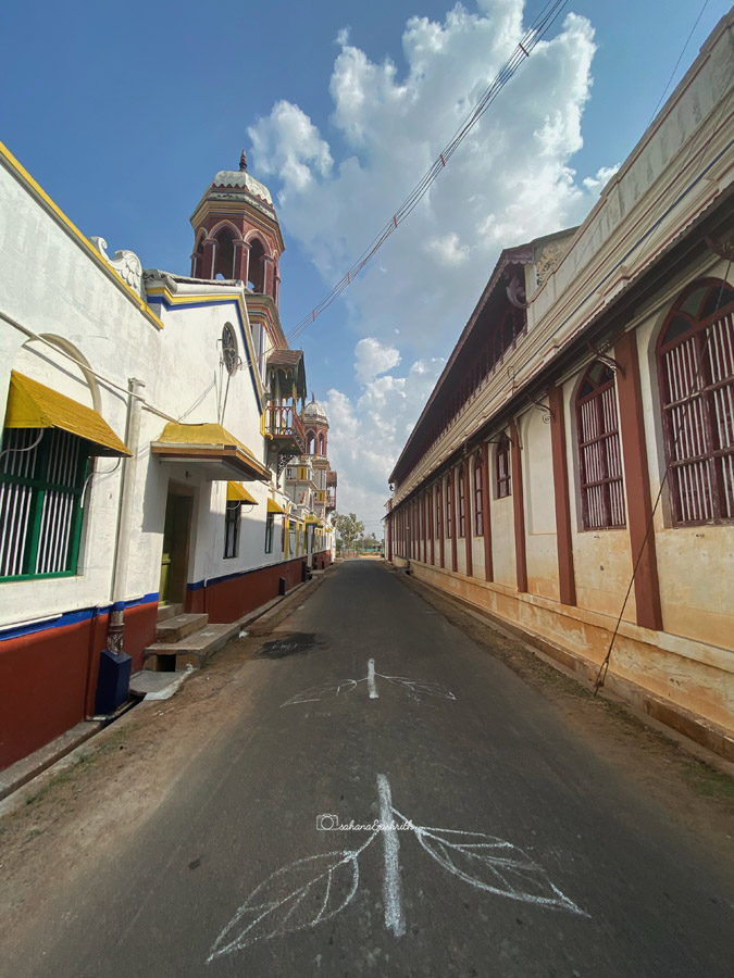 Narrow street lined with white buildings having coloued windows on the white walls at Kadiyapatti village, Tamil Nadu.