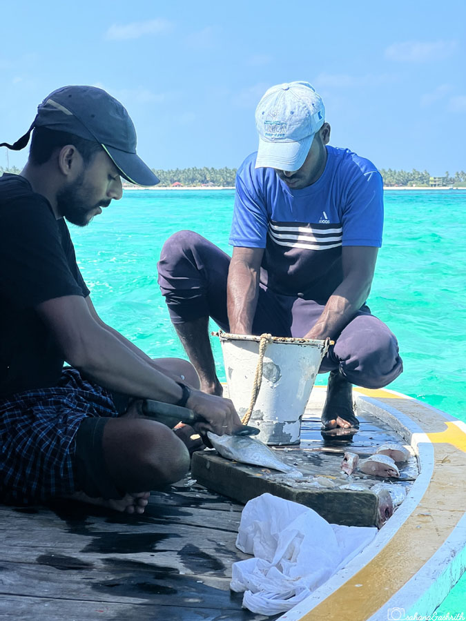 Local men cutting fish on the boat